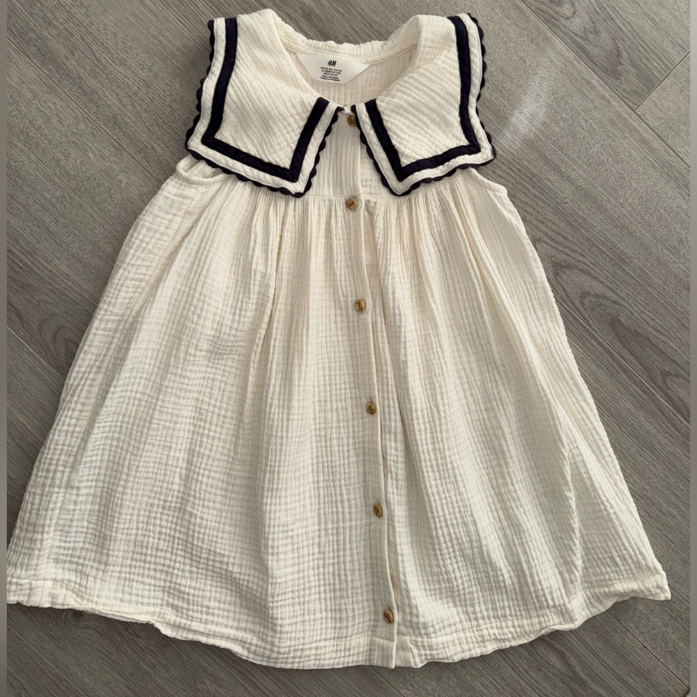 Girls sleeveless cream colored dress with navy blue piping on the collar!